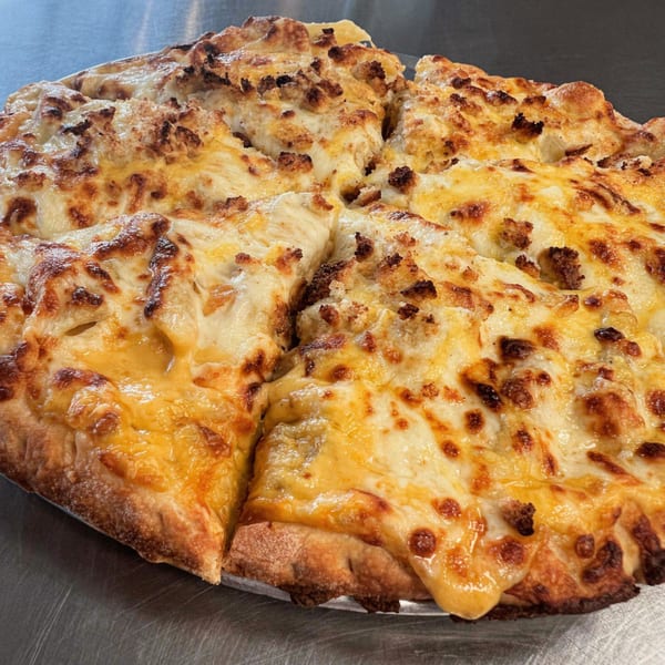 A freshly baked B Antonio's Pizza, topped with melted cheese and savory sausage, sliced and ready to eat.